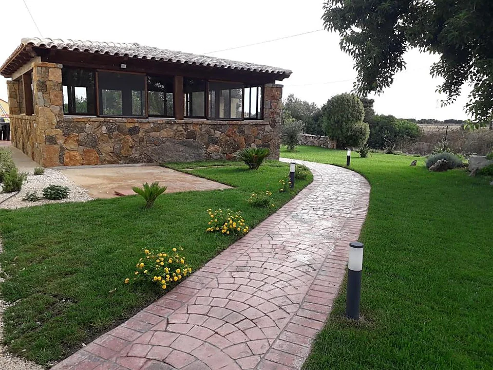 Vialetto tra il prato che porta alla sala colazione in pietra